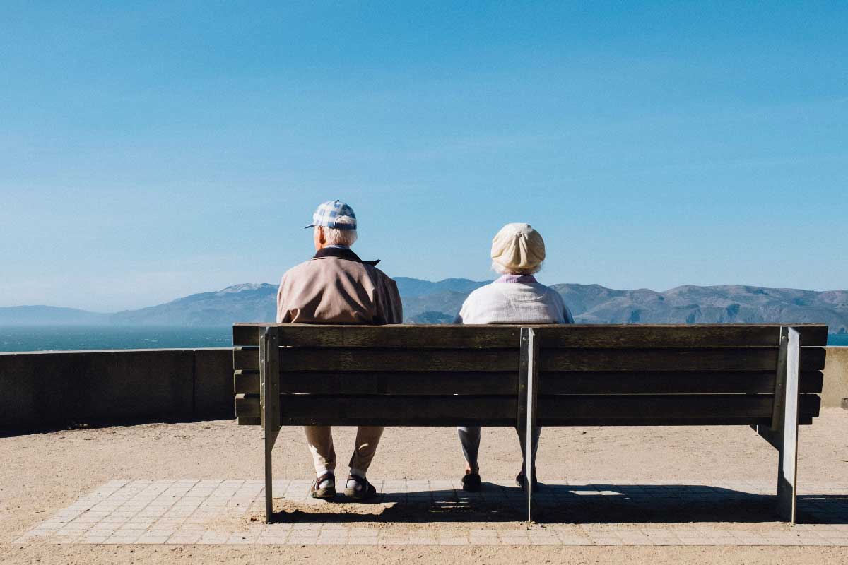 senior-couple-overlooking-landscape A senior couple sitting on a bench overlooking a landscape